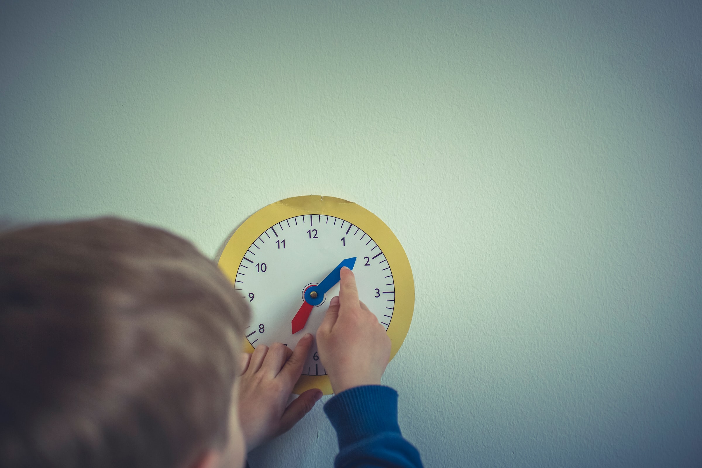 child with paper clock